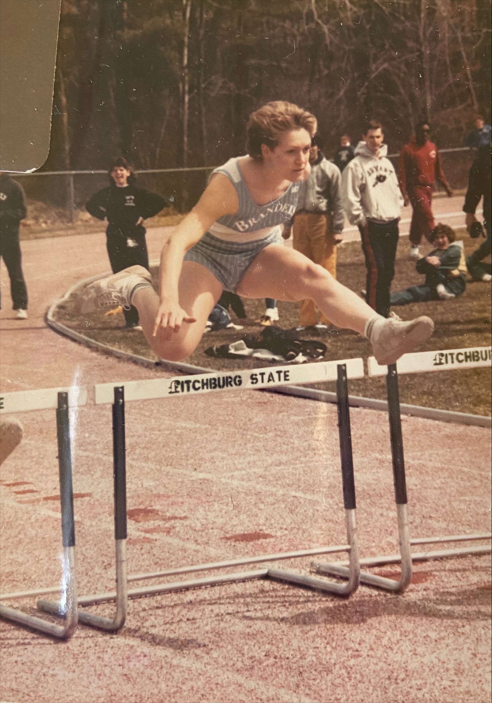 Women jumping over a set of hurdles